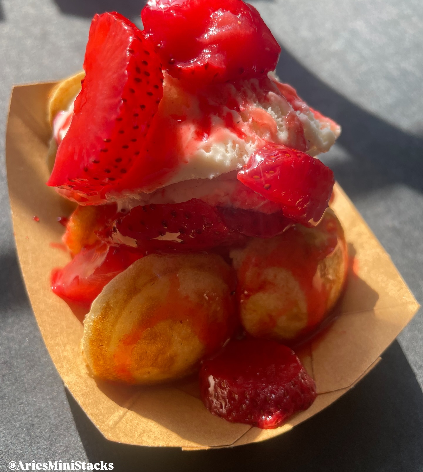 Strawberry Mini Stacks — fresh mini pancakes piled high with whipped cream, fresh strawberries, and strawberry drizzle